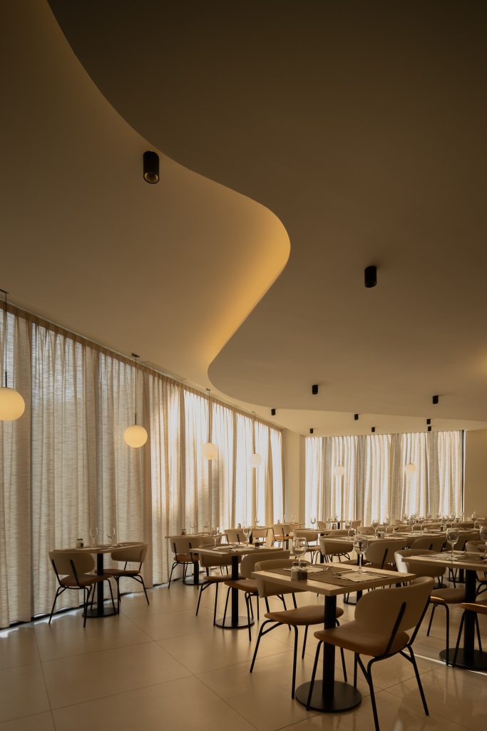 Detalle de curva arquitectónica con iluminación cálida y apliques de pared Hotel RH Arena Gandía