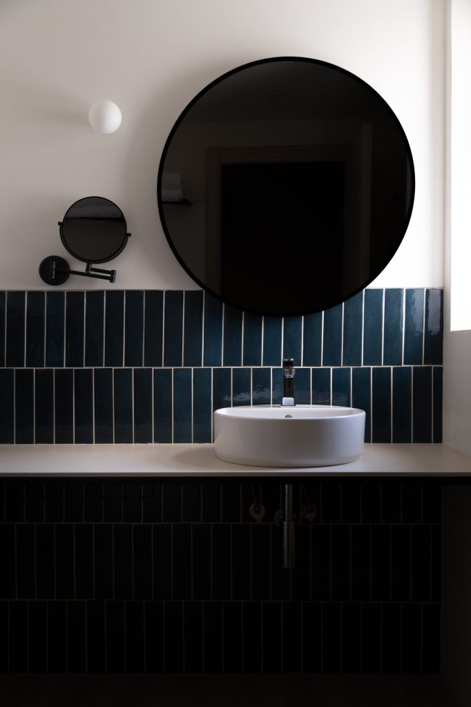 Baño de habitación con espejo circular negro y espejo de aumento Hotel RH Arena Gandía