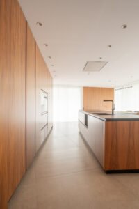 Armarios de cocina en madera junto a la isla — Casa en el Mediterráneo, Fran Esbrí Studio, Castellón | Jesús Castelló
