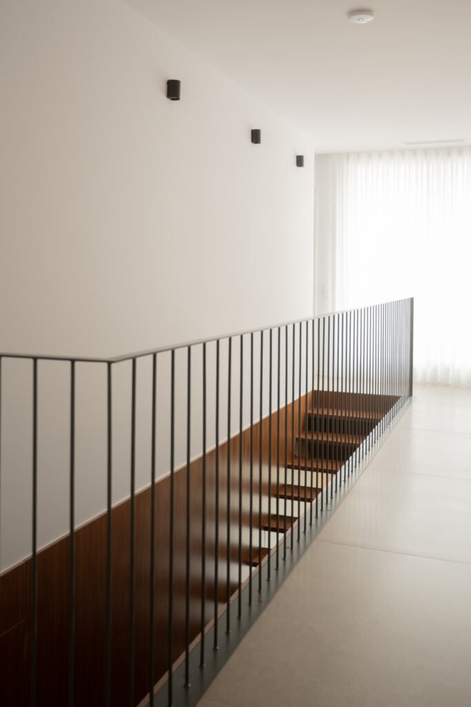 Escalera con barandilla de hierro negro y peldaños de madera — Casa en el Mediterráneo, Fran Esbrí Studio, Castellón | Jesús Castelló